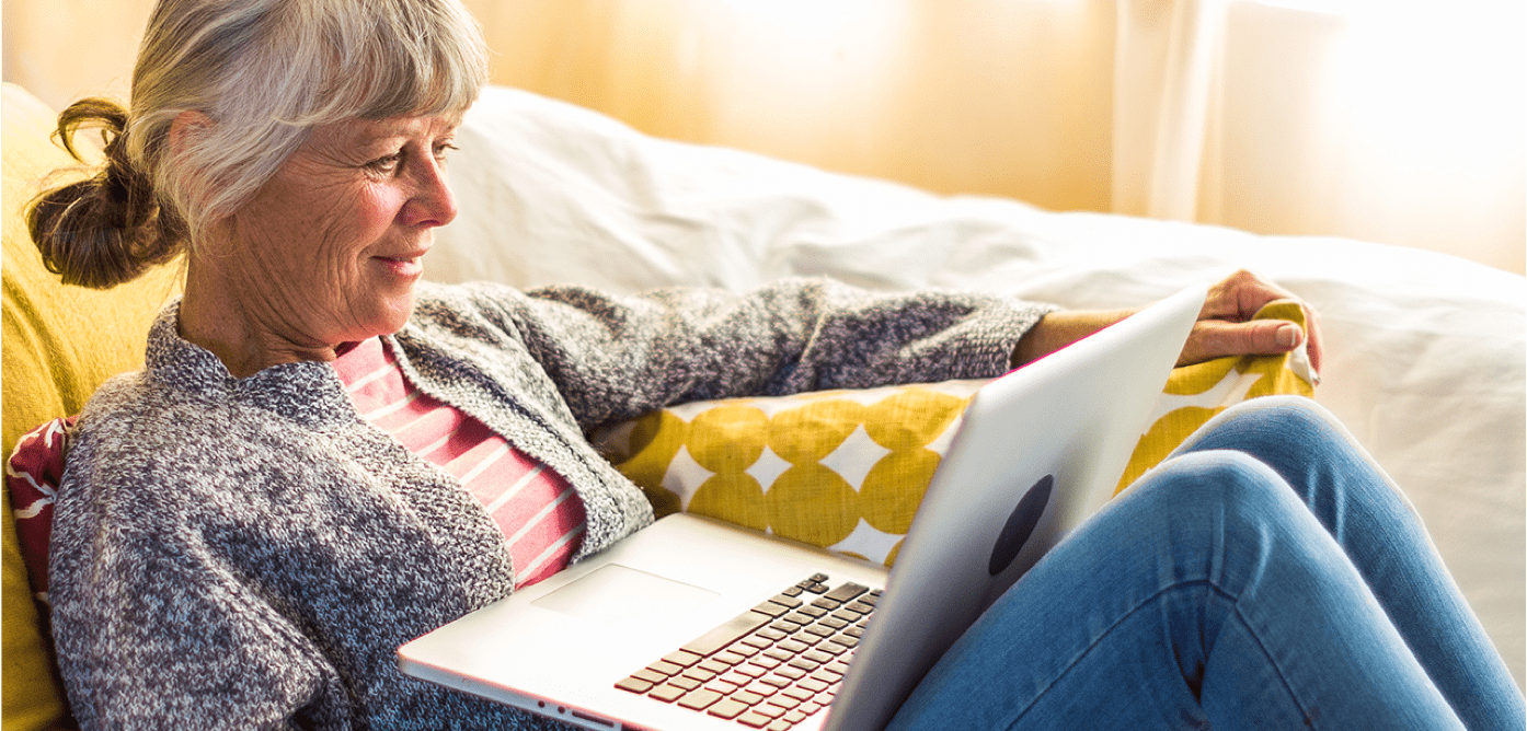 older_woman_relaxing_reading_laptop